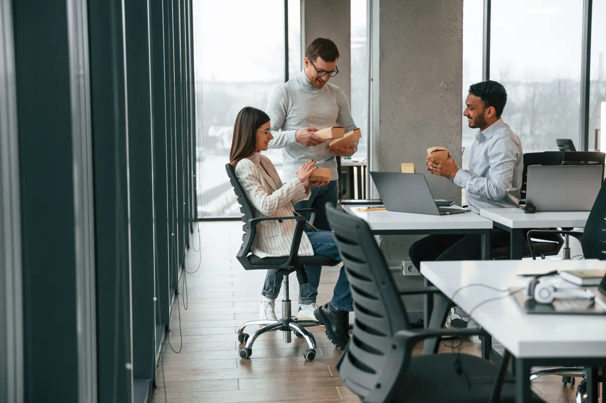 Colleagues working on laptops in a bright open-plan office